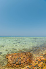 summer red sea panorama with corals and smooth stone on coastline washing by seawater