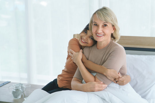 Grandma hugs granddaughter and smiling happily