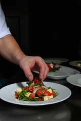 Obraz na płótnie Canvas Küchenchef richtet frischen Salat an.