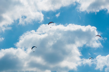 Paralotnie na tle nieba z chmurami - obrazy, fototapety, plakaty