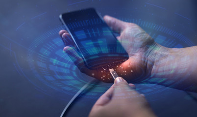 Hand connected  phone to the charger. The concept of modern technology and digital futuristic icon.
