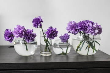 Bridal bouquet of lilac carnations in a round glass vase