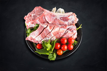 Fresh and raw meat. Whole piece of red meat ready to cook on the grill or BBQ . Background black blackboard