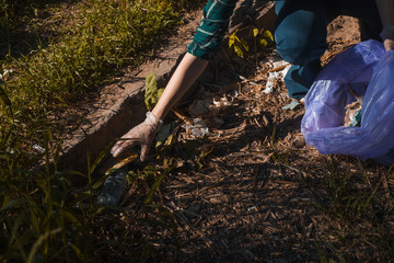 Cleaning up garbage, volunteer work. Caring for nature. People left a lot of plastic garbage in the forest.