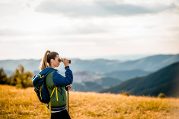 Young woman exploring with binoculars