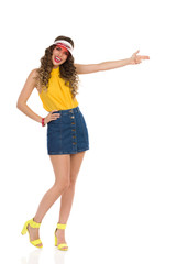 Laughing Young Woman In Jeans Mini Skirt And High Heels Is Shooting With Finger Gun