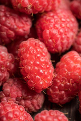 Ripe and juicy raspberry on the dark rustic background. Selective focus. Shallow depth of field.