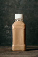 fresh coffee drink on a plastic bottle over dark background