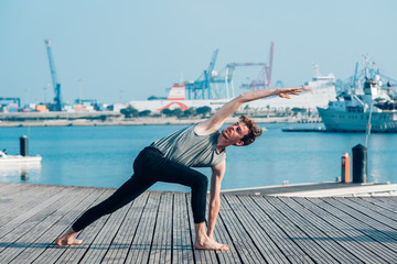 Utthita Parsvakonasana is a complicated yoga posture that stretches the trunk muscles, practiced by a man.