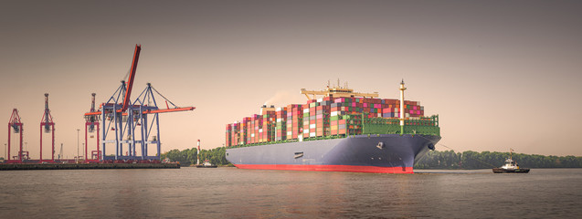 Panorama of a large container ship in Hamburg at sunrise