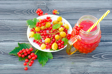 Fresh berry smoothie with red currant and yellow gooseberry on a wooden rustic table. Healthy eating, Summer food, Detox or Diet concept. Copy spase, top veiw.