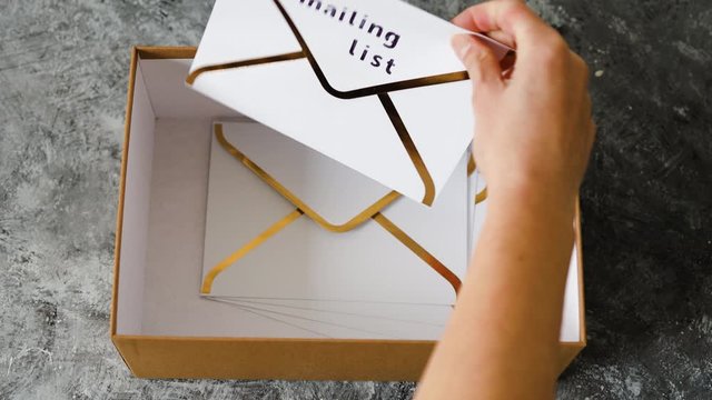 inbox organisation and clean-up, group of envelopes inside box metaphor of email inbox and hand placing mailing list