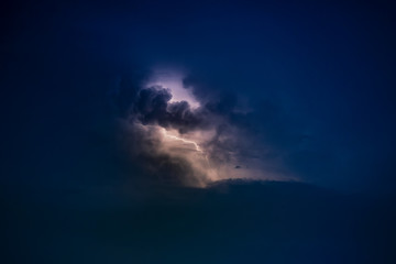 Dramatic view of heat lightning storm, thunderbolts and dramatic clouds at night time