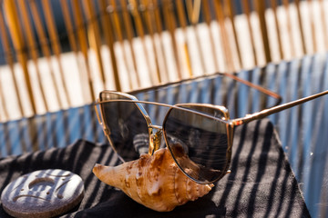 Cat eye sunglasses model profile for ladies with big lenses stay on shell in a summer day. Selective focus 