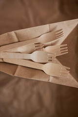 Wooden forks on a background of crumpled paper. Eco wooden plugs.