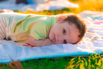 bebé acostado en el césped manta pañal serio felicidad niño recién nacido maternidad familia