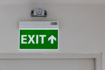 Green emergency exit sign showing the way to escape.Fire exit in the building.