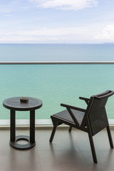 Table and chair with outdoor balcony and sea .The chair and table on balcony sea view. Chair with table set on balcony hotel room with ocean view background.
