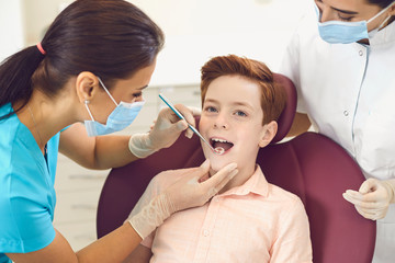 Obraz na płótnie Canvas Dentist and assistant check the teeth of a boy child in a dental clinic