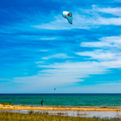 Man parasailing  on a windy Lake Huron near Tawas Point area on a windy summer day in June in Michigan, USA.