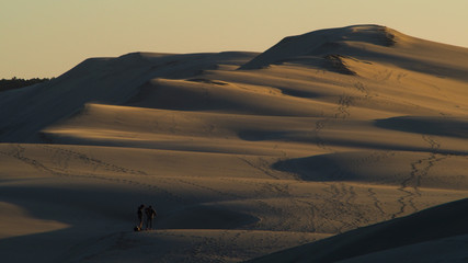 Dune du Pilat photographiée depuis le sommet d'une des dunes.  On y aperçoit deux silhouettes et...