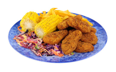 Southern fried chicken dippers, covered in spicy breadcrumbs with French fries and corn on the cob meal on a blue plate isolated on a white background