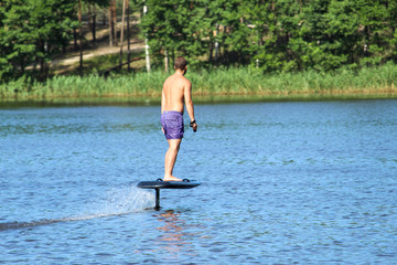 A man rides a hydrofoil on the lake