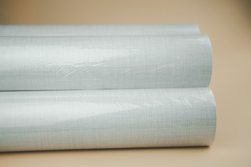 Wallpaper for decorating walls and repairs twisted into rolls in plastic packaging.