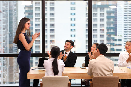 Female business CEO congratulate her team performance by clapping hand during corporate meeting in the modern office to empowering the employee's loyalty to the company 
