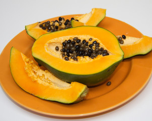 Refreshment organic papaya. Healthy lifestyle. Exotic fruit. Papaya slice on the orange plate. Isolated asian fruit.