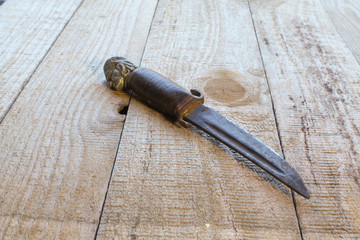 Ein altes Messer liegt auf einem Holztisch