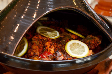 Moroccan fish tagine with chermoula, red peppers and preserved lemon close up
