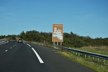 En roulant : panneau touristique sur l'autoroute A20 dans le Lot, Saint-Céré, Occitanie, France.