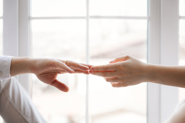 Husband and wife hold hands. Touching their hands implies love, care and tenderness