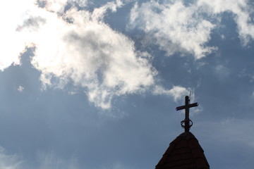 The cross at the top of the church and the beautiful blue sky 