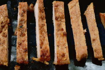fried slice salty pork sirloin with garlic and pepper on plate