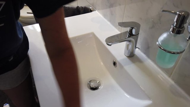 Hand mit Gummihandschuhen reinigt Bad Waschbecken Toilette WC