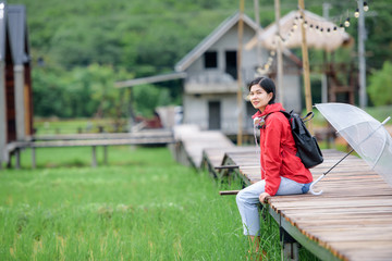 Beautiful young Asian tourists wearing red clothes travel in Thailand She likes to travel in nature.