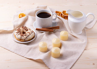 black coffee in a ceramic cup and a doughnut on rustic style table