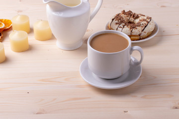 black coffee in a ceramic cup and a doughnut on rustic style table