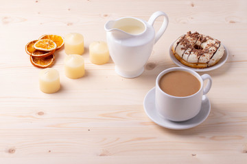 black coffee in a ceramic cup and a doughnut on rustic style table