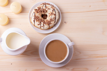 Obraz na płótnie Canvas black coffee in a ceramic cup and a doughnut on rustic style table