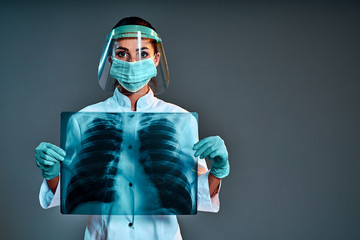 Female doctor holding chest x-ray isolated on dark gray background.