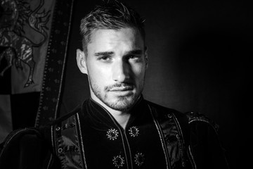 Portrait of handsome king with beard dressed in costume looking at camera
