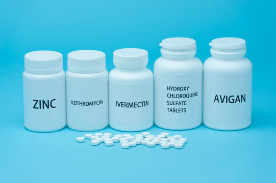 Medicine bottles for COVID-19 treatments. Scattered pills. isolated on blue background