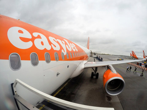 Amsterdam, Netherlands: January, 2015: Passengers board an Easy Jet airplane at Schiphol airport. Easy Jet is a British airline operating under the low-cost carrier model based at London Luton Airport