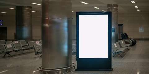 white mockup in black vertical frame stands on floor of waiting room in airport building indoor