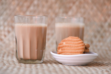 Top view of Indian Masala Chai and biscuit, traditional milk tea beverage with milk and spices Kerala India. Two cups of organic ayurvedic or herbal drink India, good in winter for immunity boosting.