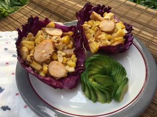 Fried egg with sausage in purple cabbage and avocado