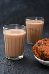Top view of Indian Masala Chai and Parippu vada traditional milk tea beverage Kerala India. Two cups of organic ayurvedic or herbal drink India, good in winter for immunity boosting.